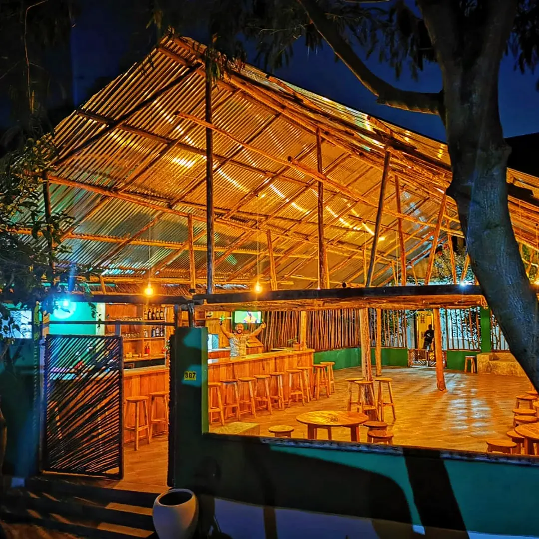 Swinging Micky's Irish Pub lit up at night on Zanzibar, Philip behind the bar with the dance floor in front of him
