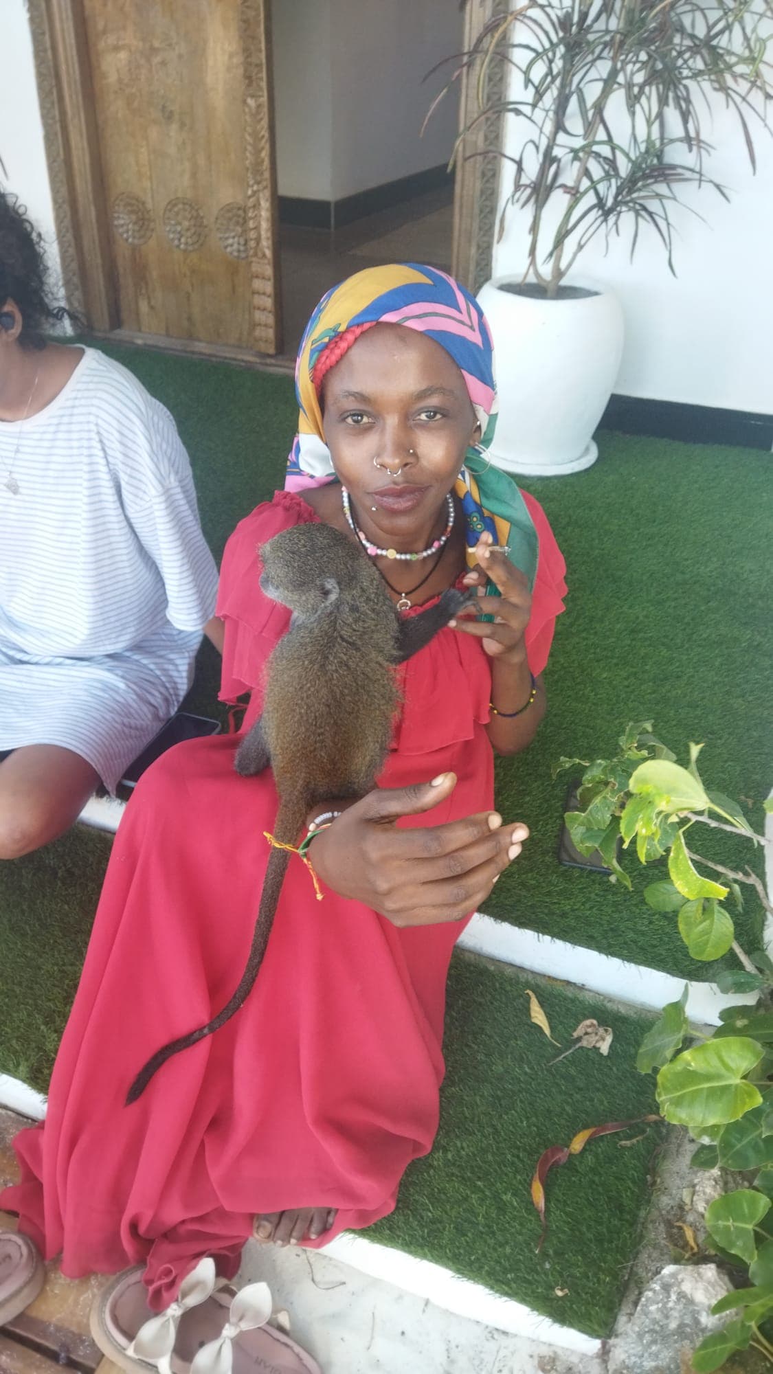 Janet holding a bushbaby on her shoulder, a moment from time spent on the Swahili Coast