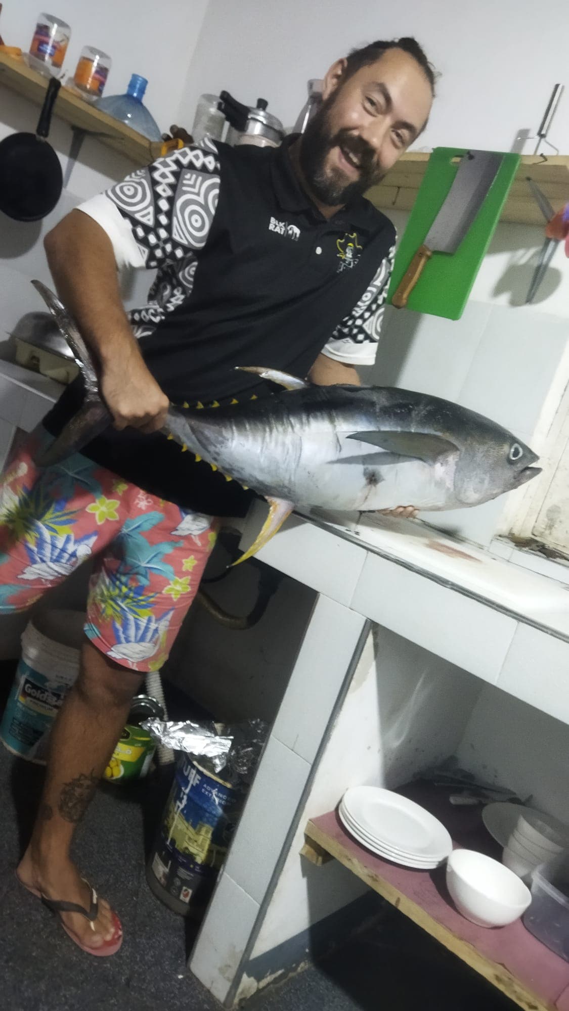 Philip, Mama Amaya's founder, holding a freshly caught yellowfin tuna in the kitchen on Zanzibar