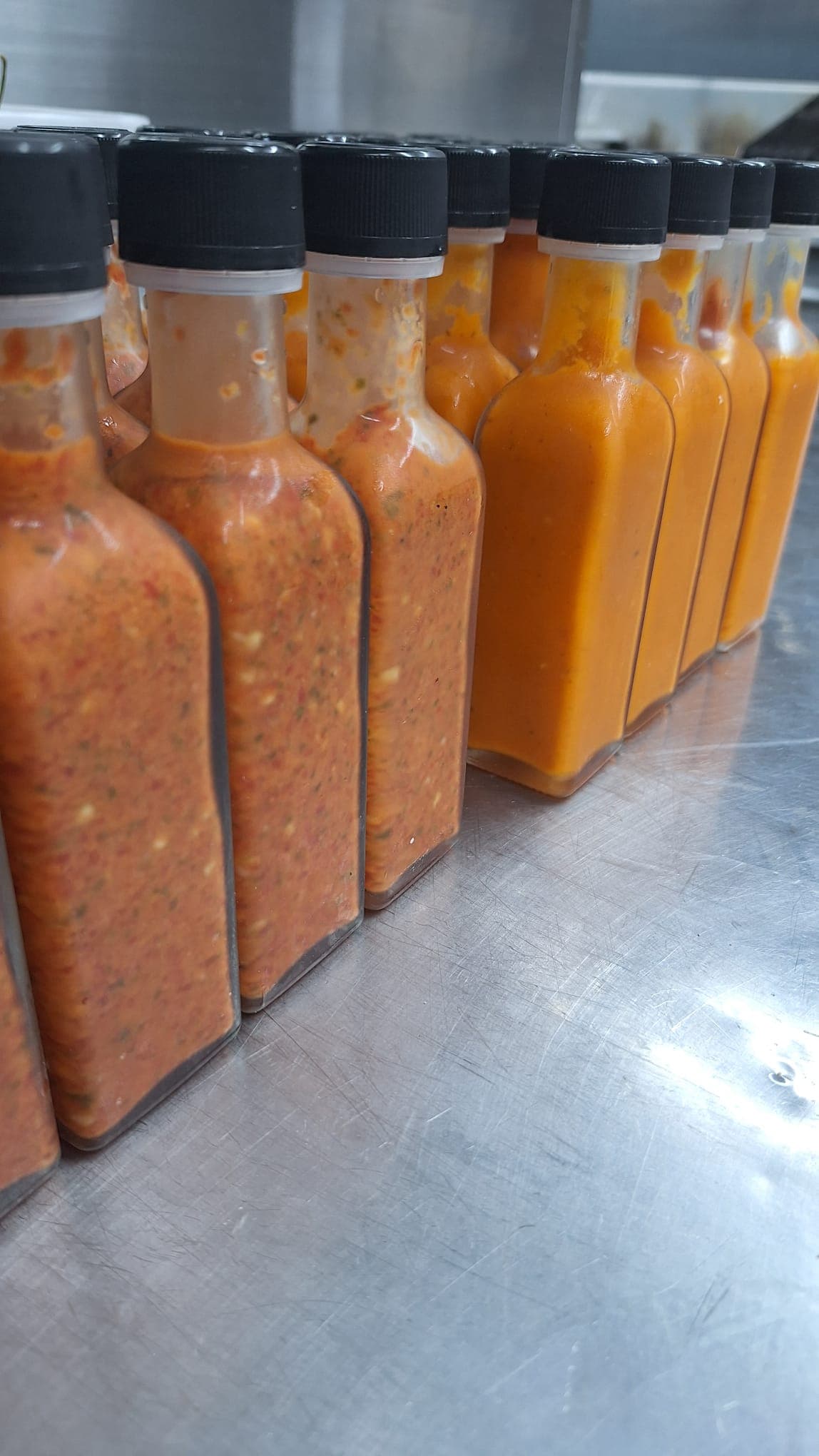 Freshly bottled Jungle Sauce (chunky, left) and Island Sauce (smooth, right), unlabeled ahead of packaging