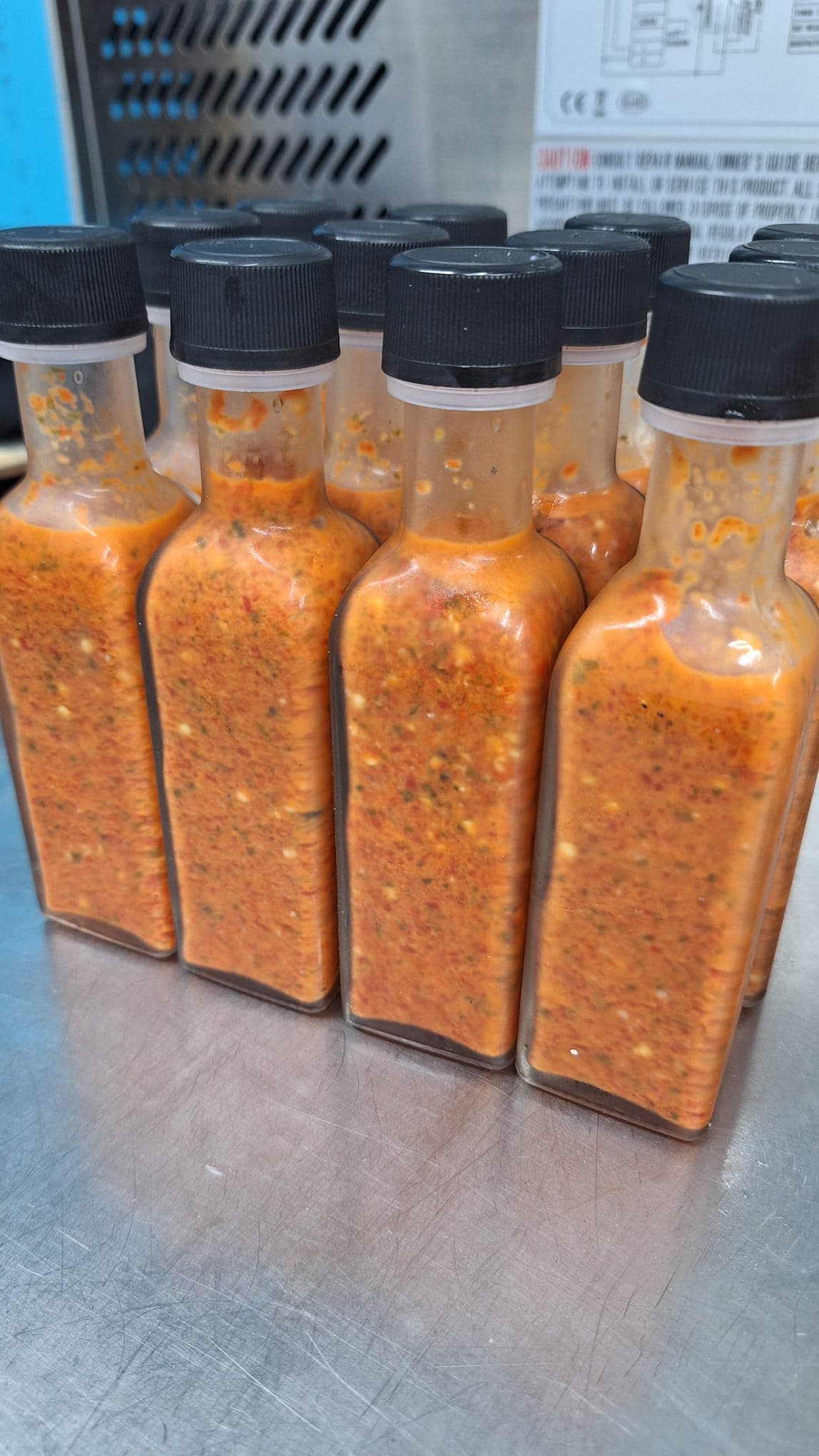 Freshly capped bottles of Jungle Sauce viewed from above, arranged in neat rows